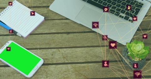 Top-down workspace with green-screen smartphone, laptop, notebook and social media icons