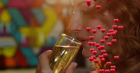 Mid-adult woman sipping champagne in lounge with heart overlays and celebration bokeh