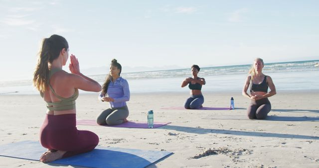 This visual offers a striking representation of women engaged in meditation on a scenic beach, emphasizing cultural diversity and a healthy lifestyle. Perfect for advertisements or articles focused on mindfulness, outdoor fitness routines, or beach wellness holidays. Suitable for promoting community group activities or wellness retreats.