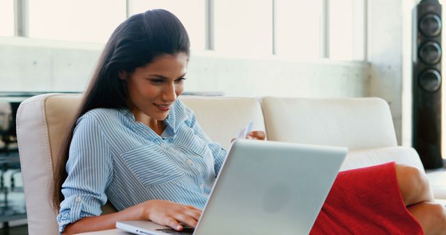 Smiling Woman Shopping Online with Laptop on Sofa - Download Free Stock Images Pikwizard.com