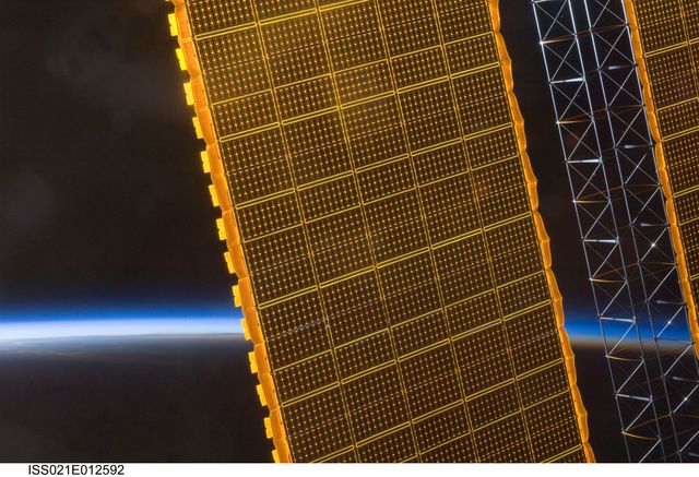 ISS021-E-012592 (25 Oct. 2009) --- Backdropped by the thin line of Earth's atmosphere and the blackness of space, a portion of an International Space Station solar array panel is featured in this image photographed by an Expedition 21 crew member aboard the station.