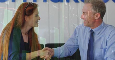 Colleagues sealing financial deal with chart overlay in office