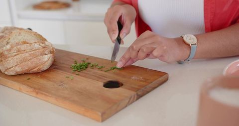 Woman Chopping Fresh Herbs in Modern Kitchen