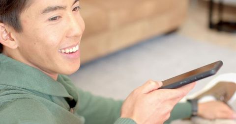 Man holding remote sitting on cozy rug in modern living room