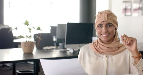 Confident Businesswoman Holding Document in Open Office Space