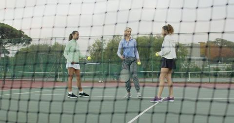 Group Tennis Training Showing Women Practicing with Coach on Outdoor Hard Court