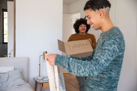 Young friends preparing clothing donation in modern home