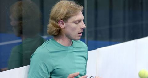 Athletic Tennis Player Holding Racket on Indoor Court