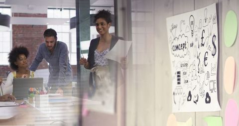 Diverse Team Collaborating in Office with Whiteboard and Charts