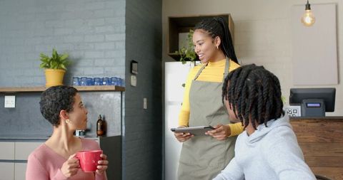 Serving Coffee and Smiles Taking Order from Diverse Customers at Modern Cafe Counter
