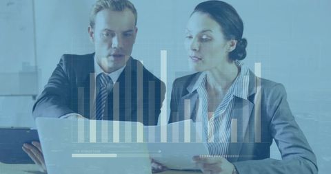 Professional colleagues analyzing financial reports with digital data