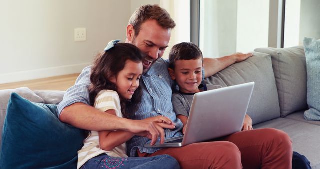 Father spending quality time with children using laptop on living room sofa - Download Free Stock Images Pikwizard.com