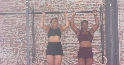 Two Women Performing Pull-Ups in Industrial Gym Setting - Download Free Stock Images Pikwizard.com