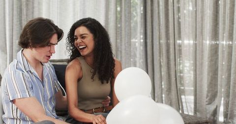 Happy Couple Preparing Balloons for Celebration at Home