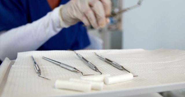 A healthcare professional, a dentist, prepares dental instruments for a procedure, with copy space. Sterilized tools are essential for patient safety and effective dental treatments.