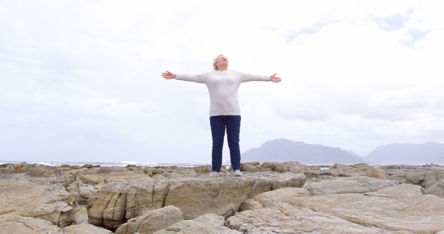 Senior Woman Spreading Arms in Freedom by Seaside Rocky Landscape - Download Free Stock Images Pikwizard.com