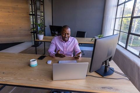 Business Professional Conducting Video Meeting in Modern Workspace
