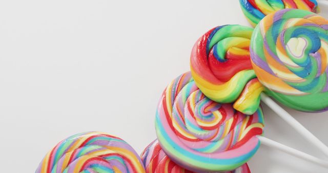 Brightly colored swirl lollipops perfect for themes like childhood, fun, and nostalgia. Ideal for use in advertisements for candy shops, marketing campaigns for confectioneries, or graphic elements in playful designs.