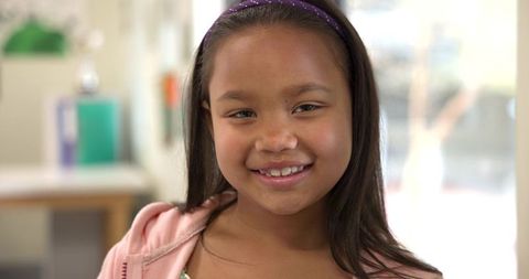 Smiling girl in classroom with hoodie and headband