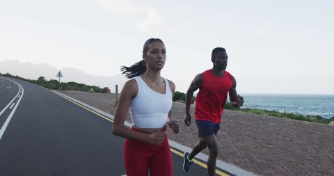 Diverse Couple Running on Scenic Coastal Road