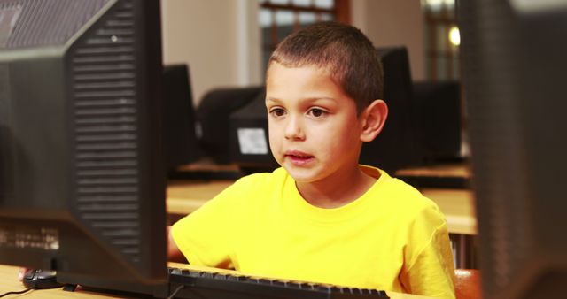 Young Boy in Yellow Shirt Using Computer in Classroom - Download Free Stock Photos Pikwizard.com