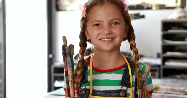 Young Artist Smiling with Paintbrushes in Studio - Download Free Stock Images Pikwizard.com