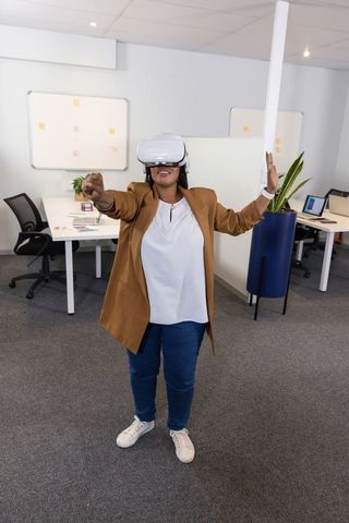 African american woman testing vr headset in modern office for immersive collaboration
