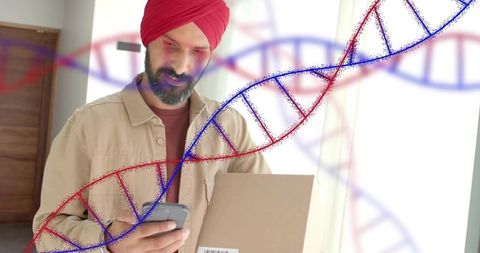 Indian man in red turban holding parcel checking smartphone with dna helix overlay concept