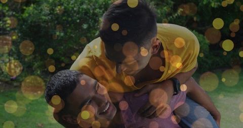 Two Friends Playing Piggyback Outdoors Laughing in Sunny Garden