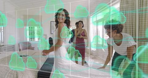 Smiling bride posing in wedding gown while friends prepare room with cloud network overlay