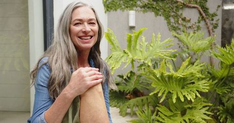 Senior Woman Relaxing on Patio Among Greenery