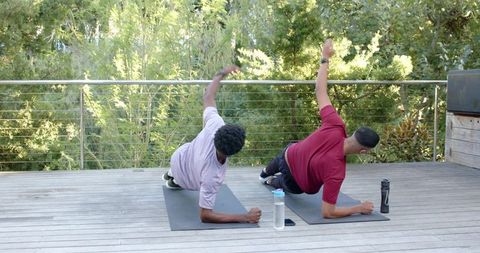Diverse Male Friends Practicing Side Plank Outdoors