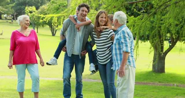 A multigenerational family is enjoying their time in a park. Grandparents and parents are walking together, showing happiness and bonding. Ideal for illustrating concepts of family togetherness, outdoor activities, and enjoying leisure time with loved ones.