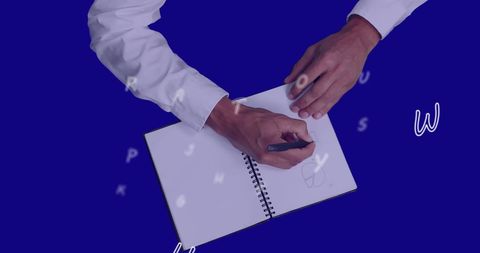 person dressed formally writing in notebook surrounded by floating letters. represents elements of creativity, brainstorming, and professional work. ideal for use in business presentations, blogs on digital transformation, educational materials about corporate environments, and marketing content related to innovative solutions.