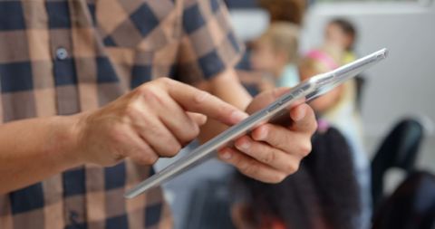 Teacher using digital tablet in active classroom setting