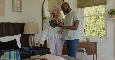 Senior Couple Preparing for Vacation While Using Digital Tablet