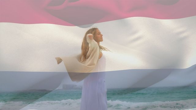 A woman with outstretched arms enjoys a windy day at the beach. The video is overlaid with the Netherlands flag, symbolizing patriotism and freedom. Great for themes of national pride, travel, and coastal serenity.