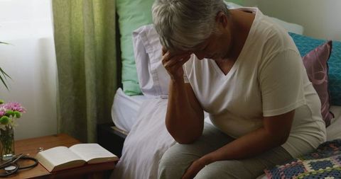 Senior woman sitting on bed depressed during pandemic