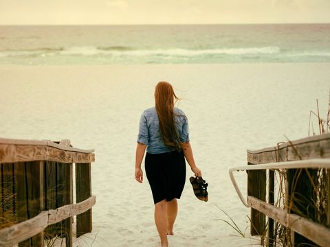 Woman Walking to Serene Beach at Sunset