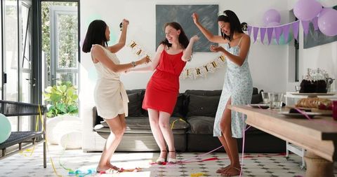 Friends Joyfully Celebrating Birthday in Bright Living Room