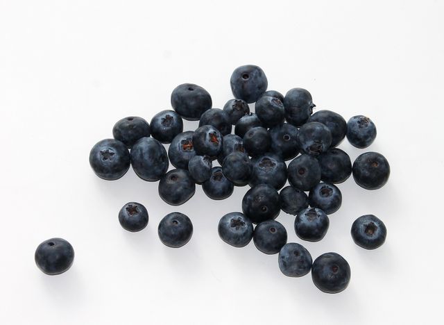 Fresh blueberries scattered on a white background showcasing healthy and organic raw fruits perfect for illustrating articles on healthy eating, superfoods, recipes, and nutrition.