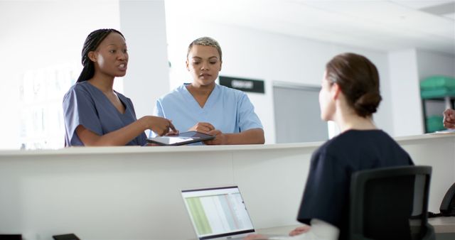 Healthcare Professionals Collaborating at Reception Desk in Modern Hospital - Download Free Stock Images Pikwizard.com