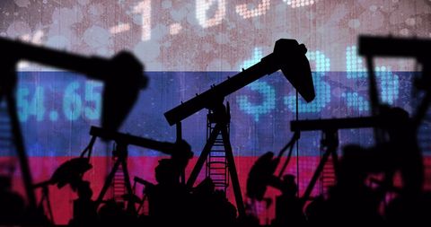 Silhouetted pump jacks against russian economic data