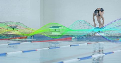 Swimmer Preparing for Dive at Indoor Pool Starting Block