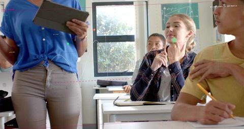 Teacher Using Tablet While Teaching High School Students in Bright Modern Classroom