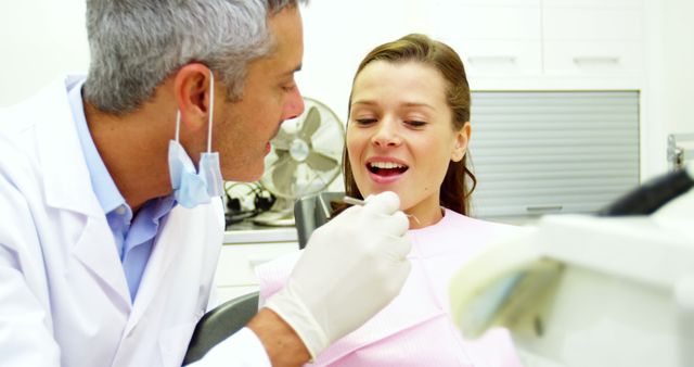 Dentist examining a female patient with tools in dental clinic 4k