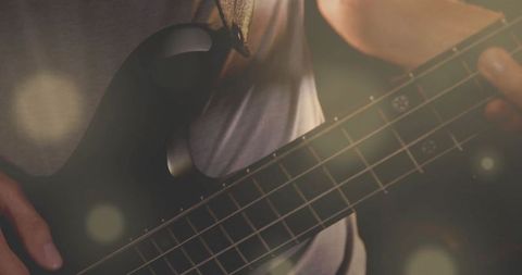 Musician Playing Bass Guitar on Stage with Warm Lens Flares