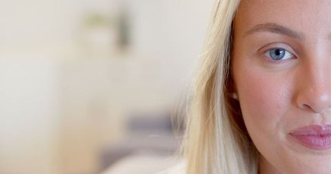 Contemplative Woman in Minimalist Living Space with Neutral Expression