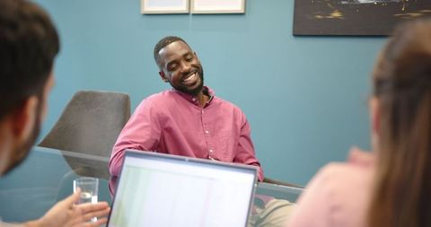 Smiling Professional in Meeting with Colleagues in Modern Office