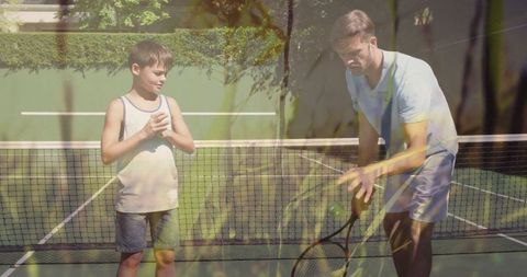 Father Coaching Son on Tennis Court Outdoors